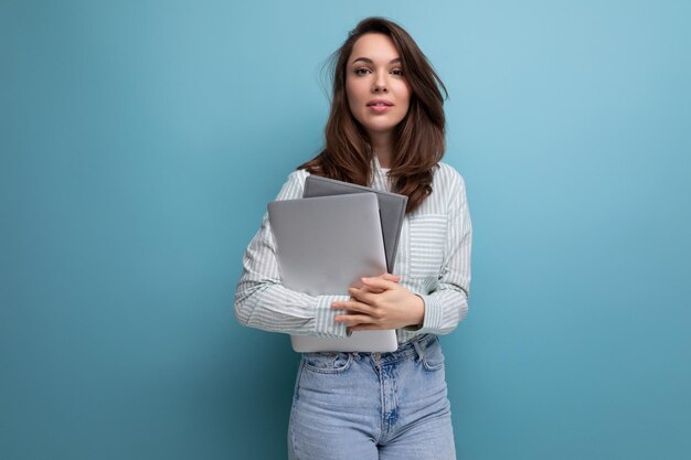 Brunette jeune femme d'affaires en chemise avec documents et ordinateur portable sur fond avec rythme de copie