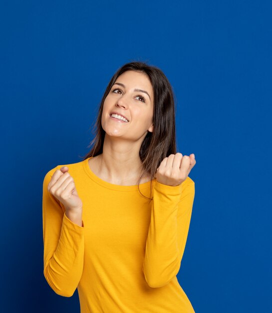 Brunette jeune femme gesticulant sur mur bleu