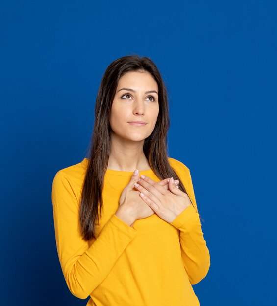 Brunette jeune femme gesticulant sur mur bleu