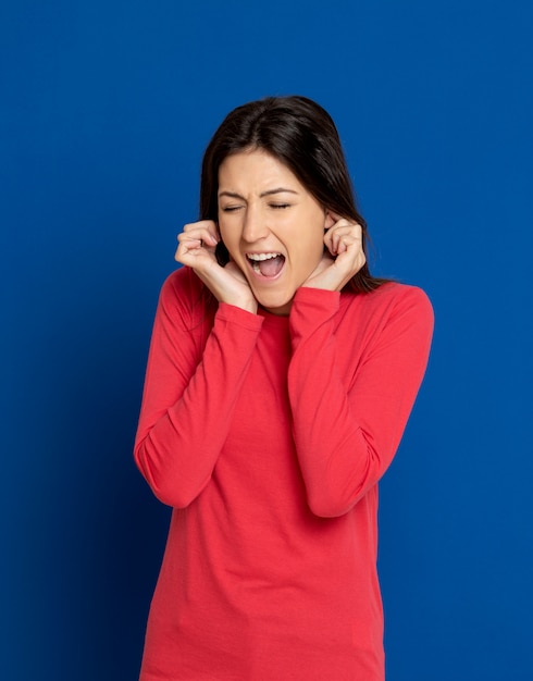 Brunette jeune femme gesticulant sur mur bleu