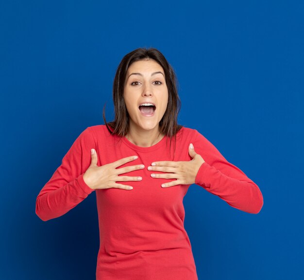 Brunette jeune femme gesticulant sur mur bleu