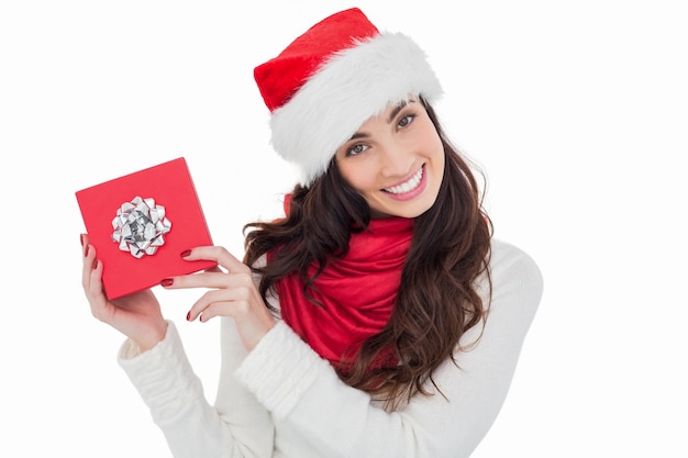 Brunette joyeuse présentant un cadeau de Noël