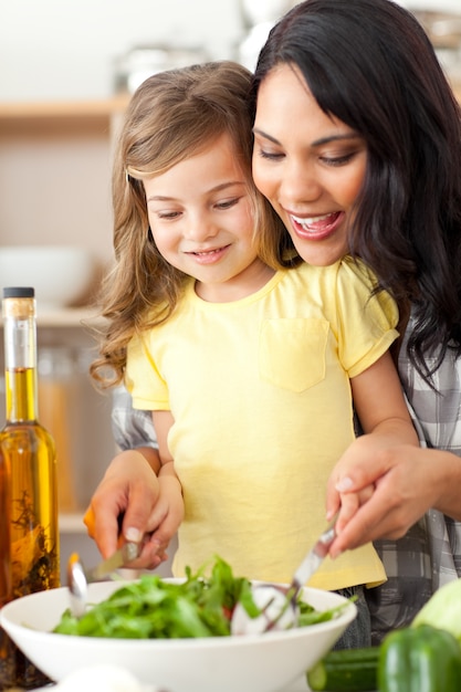 Brunette mère aidant sa fille à préparer une salade