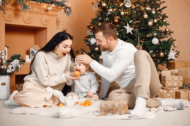 Brunette mère père et petit fils assis près de l'arbre de Noël