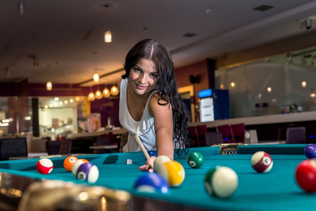 Brunette passe du temps à jouer au billard américain