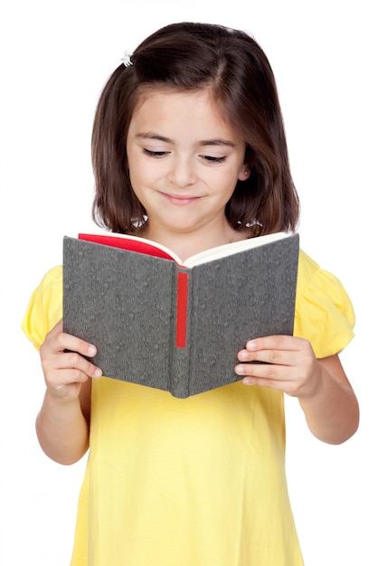 Brunette petite fille lisant un livre isolé sur un fond blanc