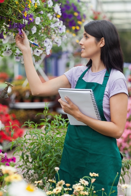 Brunette Regarde des fleurs et prendre des notes