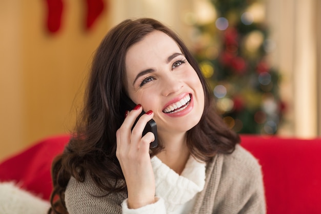 Brunette souriante au téléphone le jour de Noël
