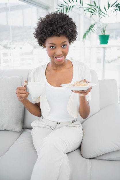 Brunette souriante prenant son petit déjeuner