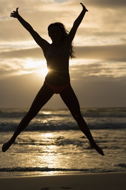 Brunette sportive qui s&#39;étend sur la plage