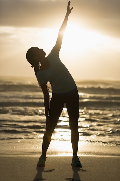 Brunette sportive qui s&#39;étend sur la plage