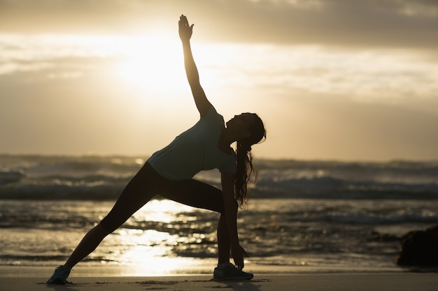 Brunette sportive qui s&#39;étend sur la plage