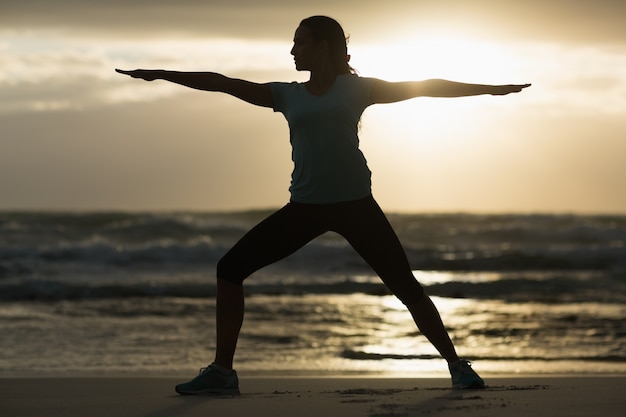 Brunette sportive qui s&#39;étend sur la plage