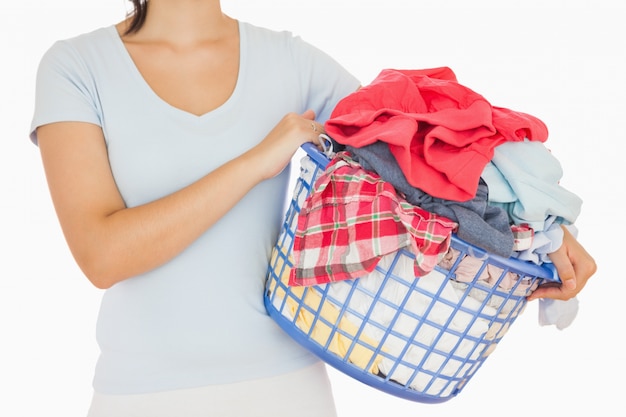 Brunette tenant un panier plein de linge