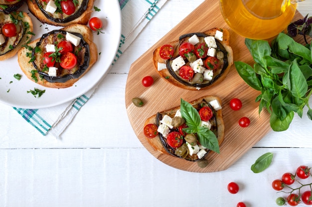 Bruschetta à l'ail avec aubergines, feta, tomates cerises, câpres. Apéritif végétarien utile. Cuisine italienne. La vue de dessus