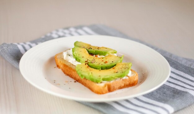 Bruschetta au fromage à la crème et avocat dans une assiette sur la table