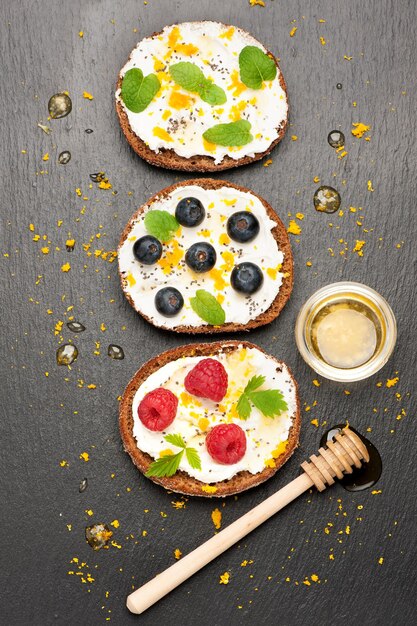 Bruschetta au miel de fromage de chèvre et baies fraîches sur fond de pierre vue de dessus