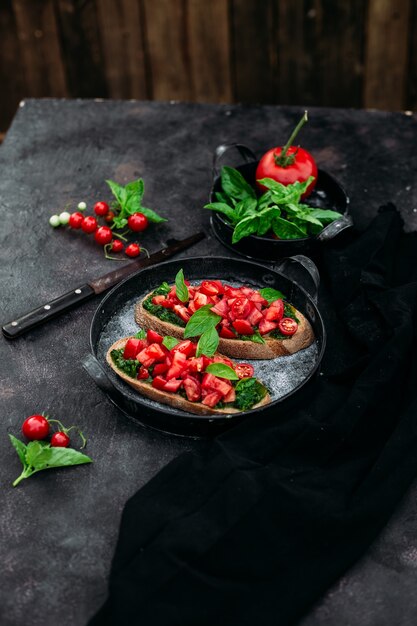 Bruschetta au pesto et tomates sur fond sombre