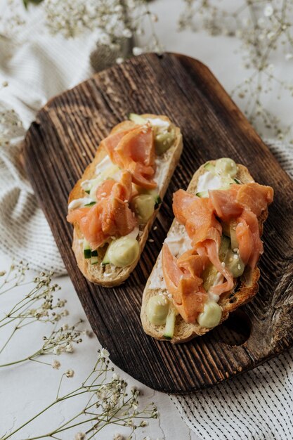 Photo bruschetta au saumon fumé servi sur une planche en bois