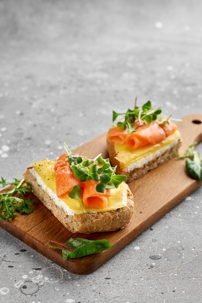 Bruschetta au saumon. Pain de grains entiers au saumon, fromage sur une planche de bois