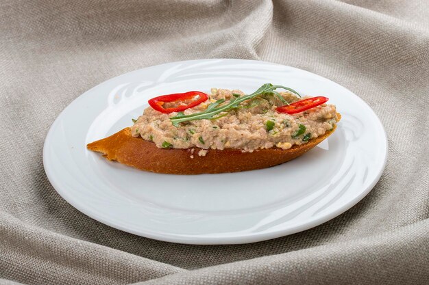 Bruschetta au tartare de poisson sur une assiette blanche sur fond textile