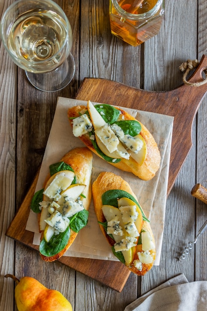 Bruschetta aux épinards, poire et fromage bleu. Du vin. La nourriture végétarienne. Alimentation équilibrée. Veganisme. Régime.