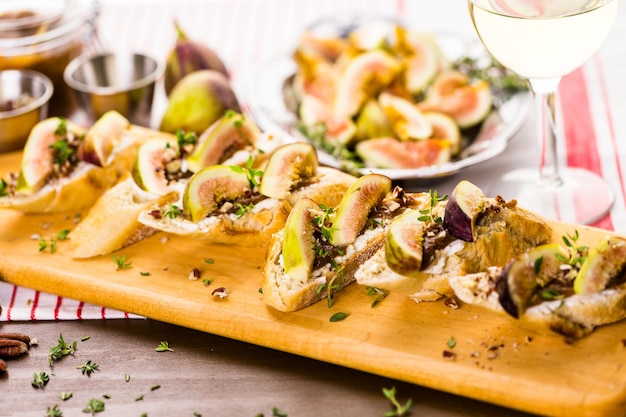 Bruschetta aux figues avec des figues de Californie bio sur une planche à découper.