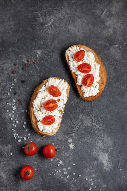 Photo bruschetta aux tomates et au fromage sur fond sombre