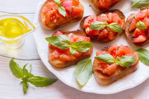 Bruschetta aux tomates et basilic sur une planche de bois