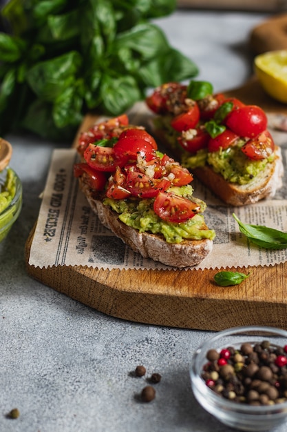 Bruschetta aux tomates avec guacamole à l'avocat, basilic et huile d'olive