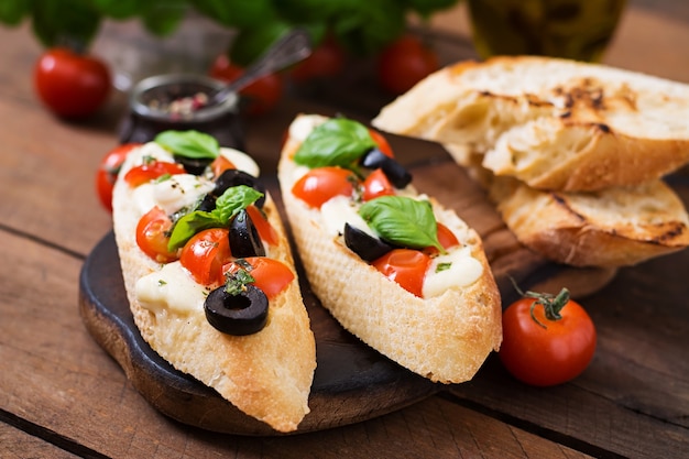 Bruschetta aux tomates, mozzarella, olives et pesto au basilic