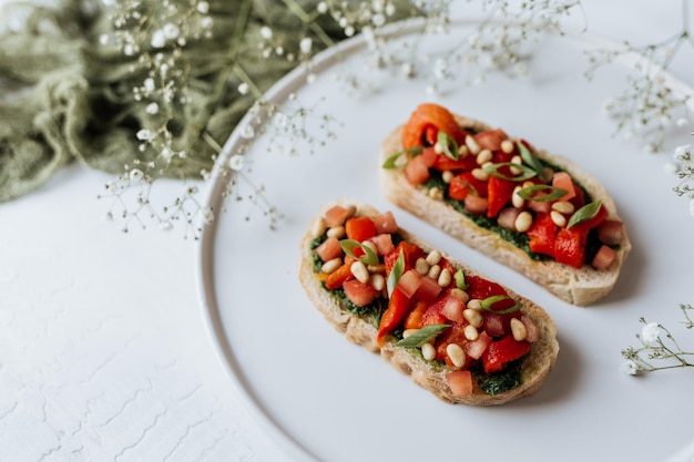 Photo bruschetta aux tomates pesto et noix servi sur une plaque en céramique