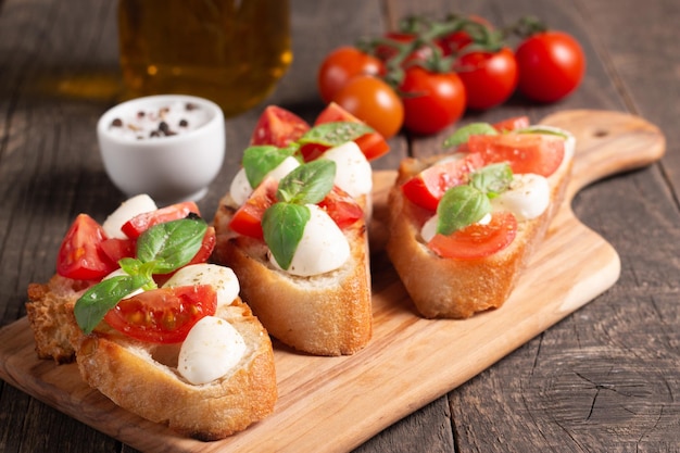 Bruschetta caprese fraîchement préparée à la tomate, au basilic et au fromage. Tapas italiennes, antipasti aux légumes, il