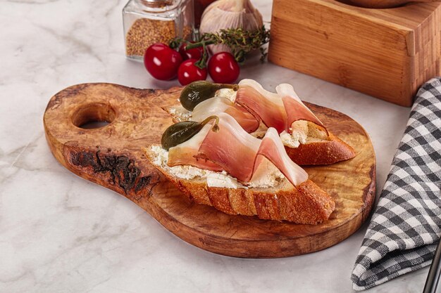 Photo bruschetta avec du jambon et des baies de capercaillie