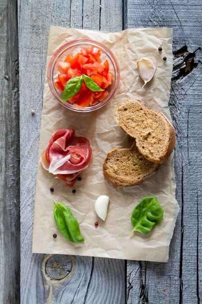 Bruschetta et ingrédients sur fond de bois rustique