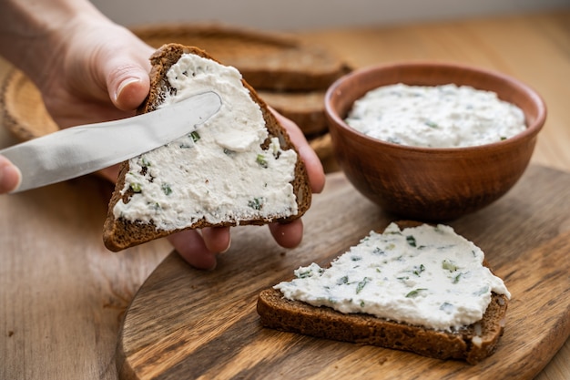 Bruschetta de pain de grains entiers avec du fromage à la crème caillé blanc sur une surface grunge de gingembre