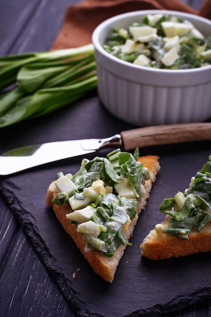 Bruschetta avec salade Ramson sur fond d&#39;ardoise