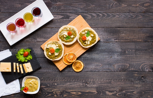 Bruschetta savoureuse et délicieuse avec avocat, tomates, fromage, herbes, chips et liqueur.