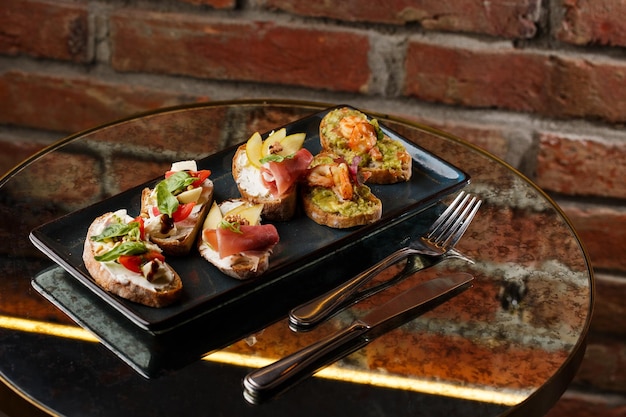 Photo bruschettas aux légumes commencez les plats avec des tomates cerises, du fromage à la crème d'avocat et des crevettes composition alimentaire savoureux repas italien