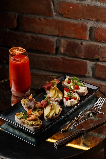 Bruschettas aux légumes Commencez les plats avec des tomates cerises, du fromage à la crème d'avocat et des crevettes Composition alimentaire savoureux repas italien