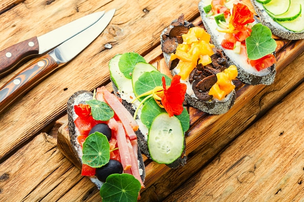 Bruschettas d'été ou canapé avec fromage à la crème, bacon et légumes. Bruschetta italienne traditionnelle