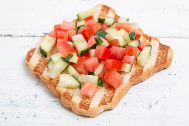 Bruschettas italiennes avec des tranches de concombre de tomate et de légumes. Pain végétarien au concombre et à la tomate.