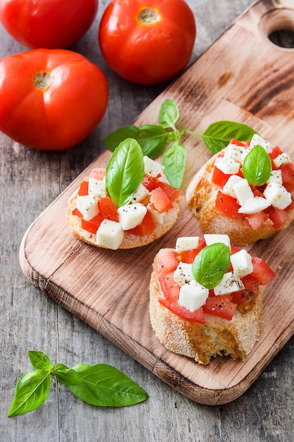 Bruschettas à la salade Caprese isolées sur une table en bois