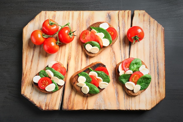 Bruschettas savoureuses aux tomates cerises et mozzarella sur planche de bois