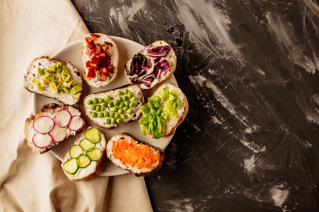 Brushetta ou tapas espagnoles traditionnelles. Des amuse-gueules aux antipasti italiens sur une planche de bois.