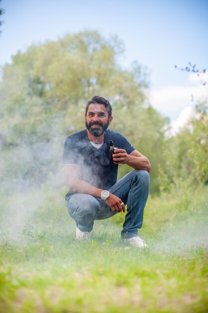 Brutalsmoker bénéficiant d'un appareil à fumée électronique sur l'herbe de la forêt