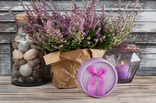 Bruyère rose et bougie dans un vase en verre géométrique