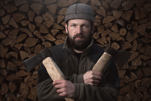 Bûcheron barbu devant une bûche de bois de chauffage. Vie à la campagne.