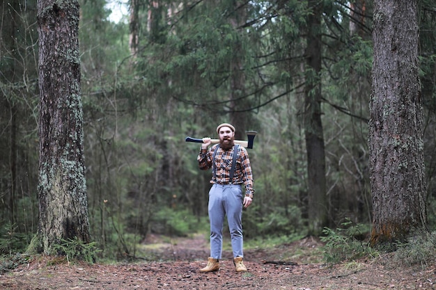 Un bûcheron barbu avec une grande hache examine l'arbre avant de l'abattrexA