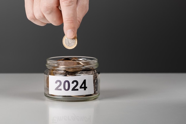 Budget 2024 bannière homme d'affaires met une pièce dans un pot de change calcul financier et planification plan annuel intelligent pour économiser de l'argent concept de gestion d'entreprise